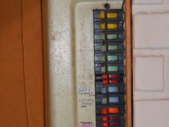 Photo of a Zinsco electrial panel. Half of it is covered up.